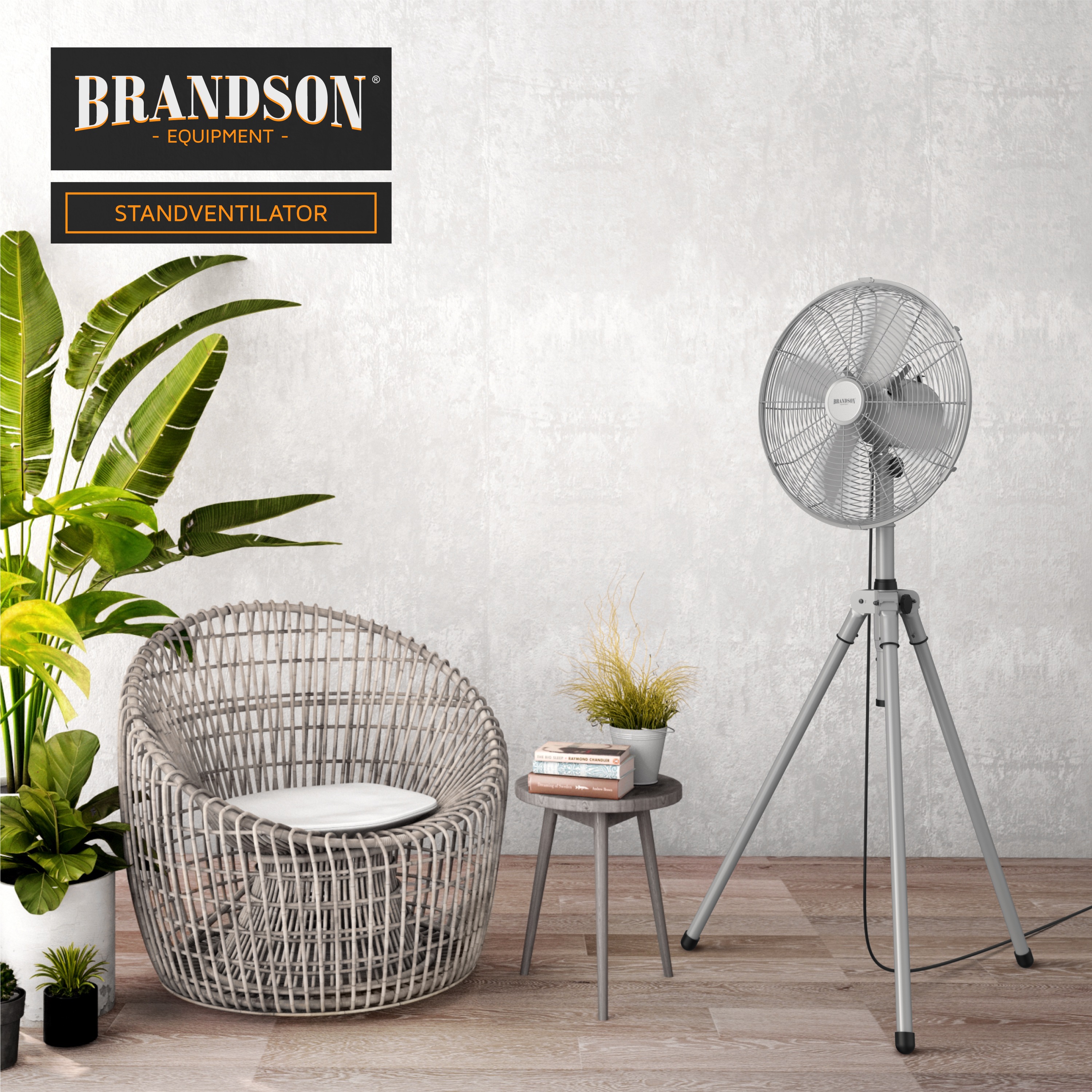 Brandson Standventilator mit elegantem Design, silberner Farbe und einstellbarer Höhe, platziert neben einem modernen Stuhl und Pflanzen.