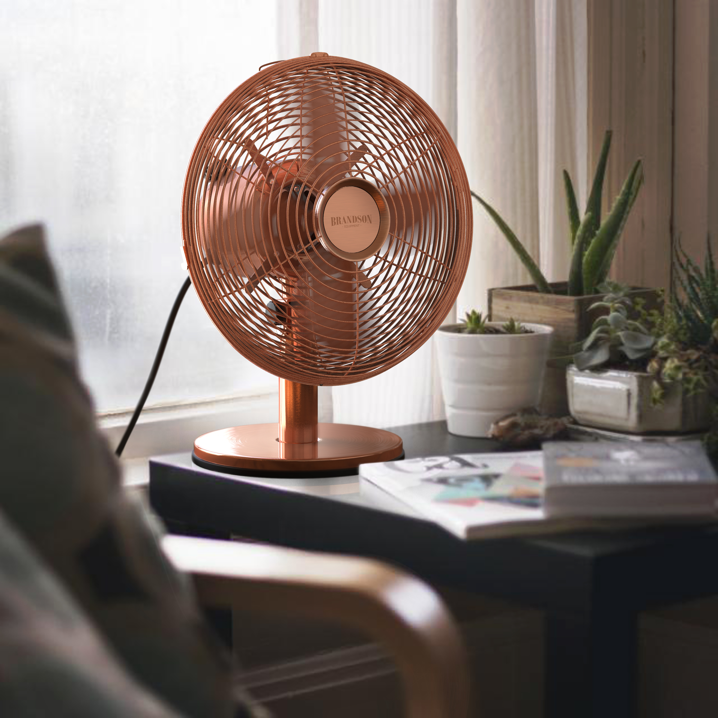 Brandson Standventilator in Kupferfarbe mit runder Basis und verstellbarem Kopf, platziert auf einem Tisch neben Pflanzen.