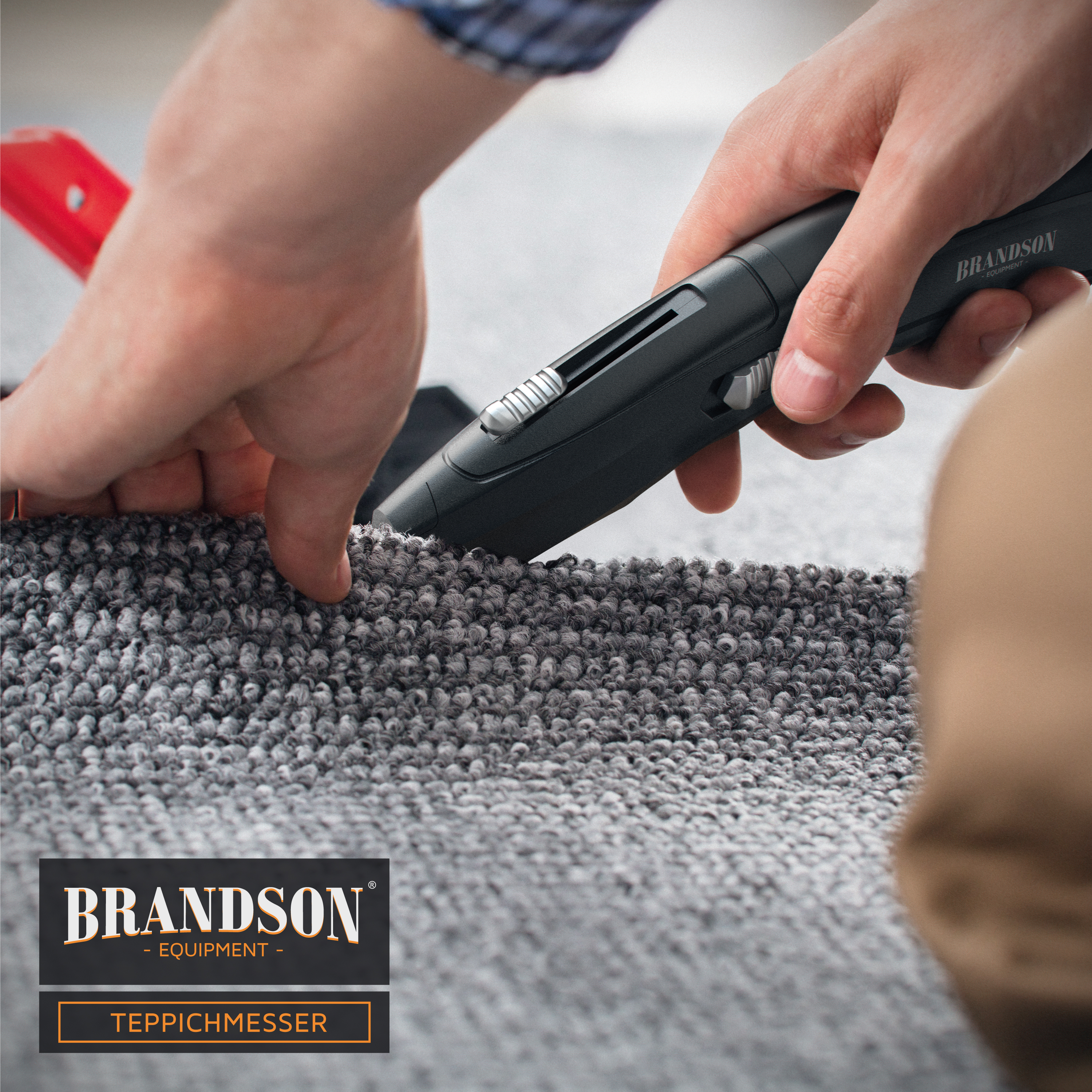 Brandson Teppichmesser mit schwarzem Griff und Klinge, in der Anwendung auf grauem Teppichboden.