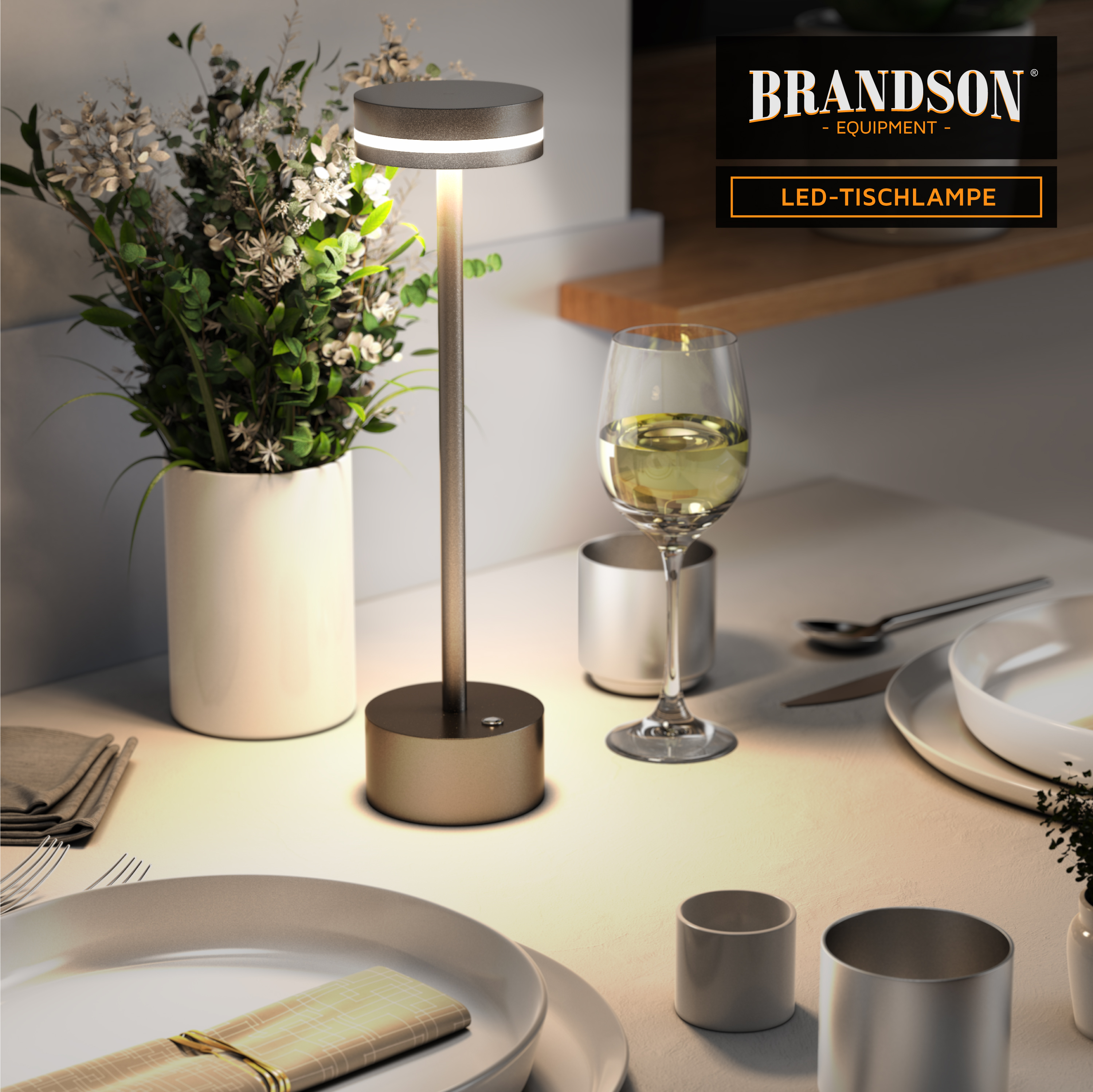 Brandson LED-Tischlampe mit elegantem Metalldesign, zylindrischem Schirm und rundem Sockel, platziert auf einem Esstisch mit dekorativen Elementen.