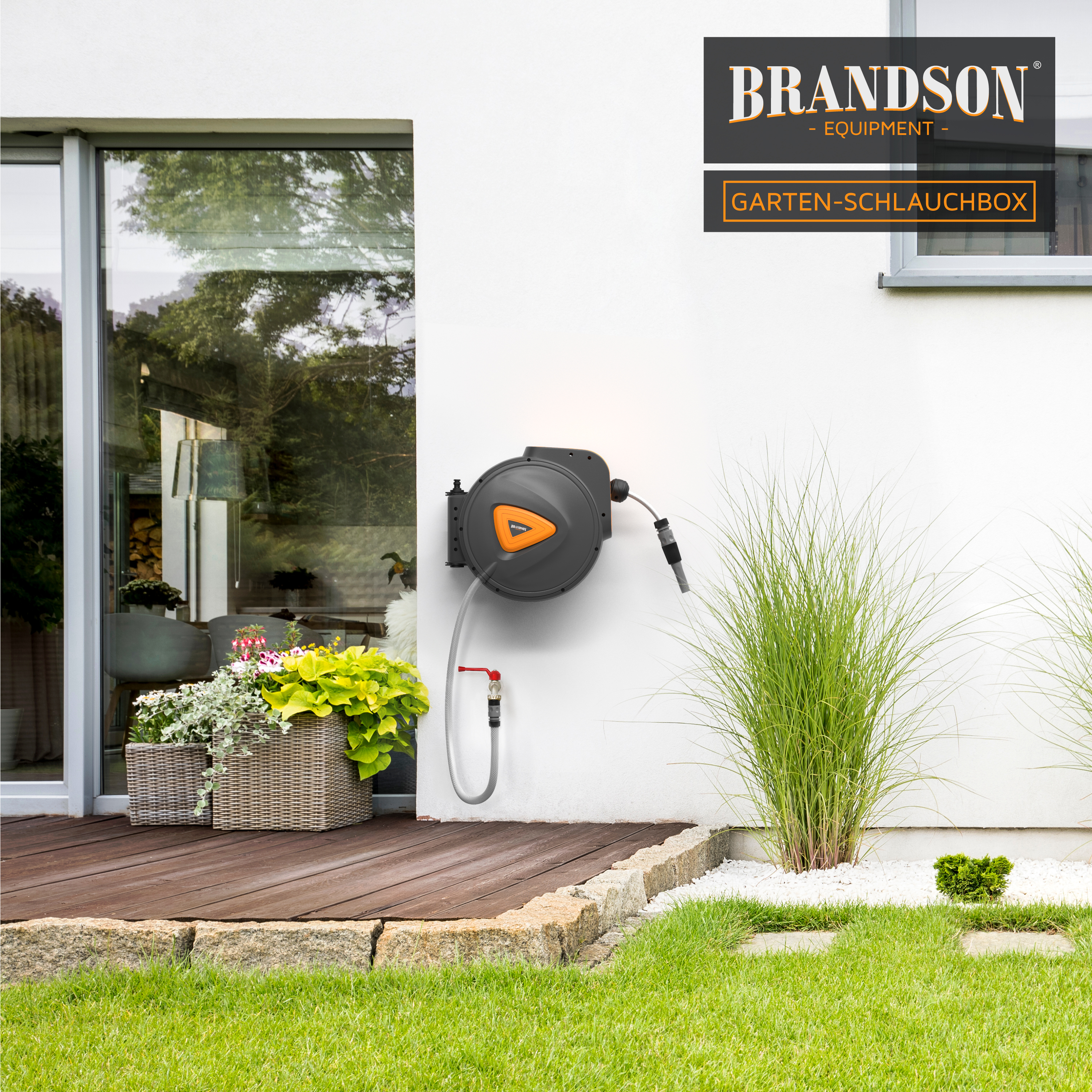 Brandson Garten-Schlauchbox in grau mit orangefarbenem Griff, an einer Wand montiert, mit sichtbarem Schlauch und Wasserhahn.