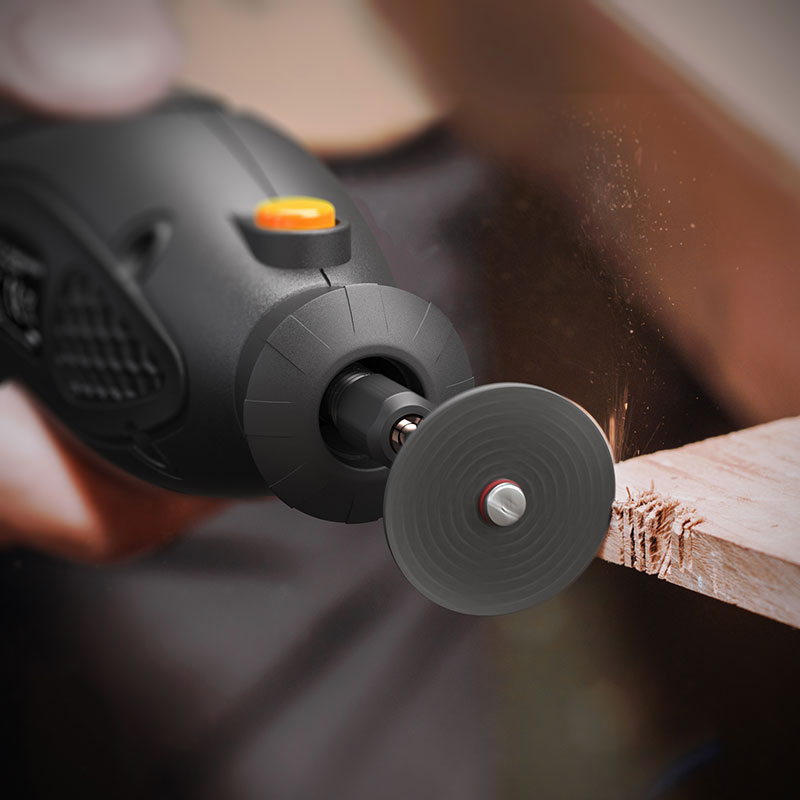 Brandson Dremel mit rotierender Trennscheibe, schwarz mit orangefarbenem Knopf, in Aktion beim Schneiden von Holz.