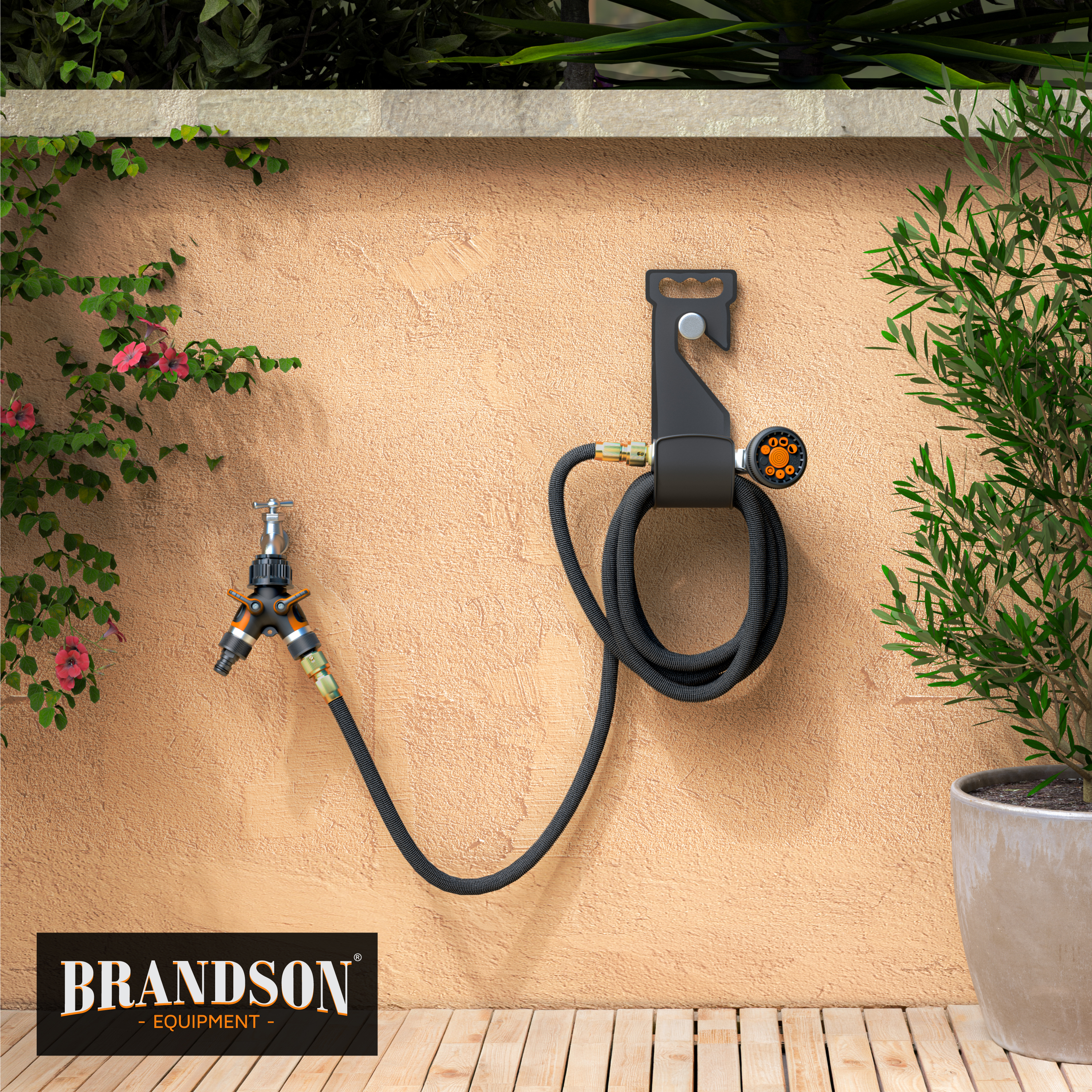 Brandson Gartenschlauchhalter mit schwarzem Schlauch und Multifunktions-Sprühdüse, montiert an einer Wand, umgeben von Grün.