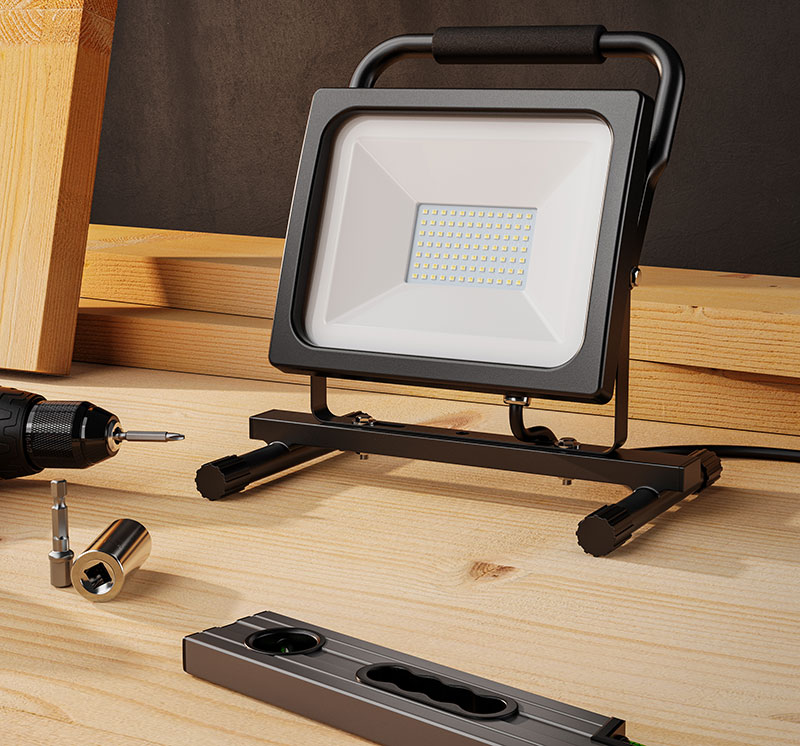 Brandson LED-Arbeitsleuchte mit schwarzem Gehäuse, stabiler Halterung und Kabel, auf einem Holztisch platziert.