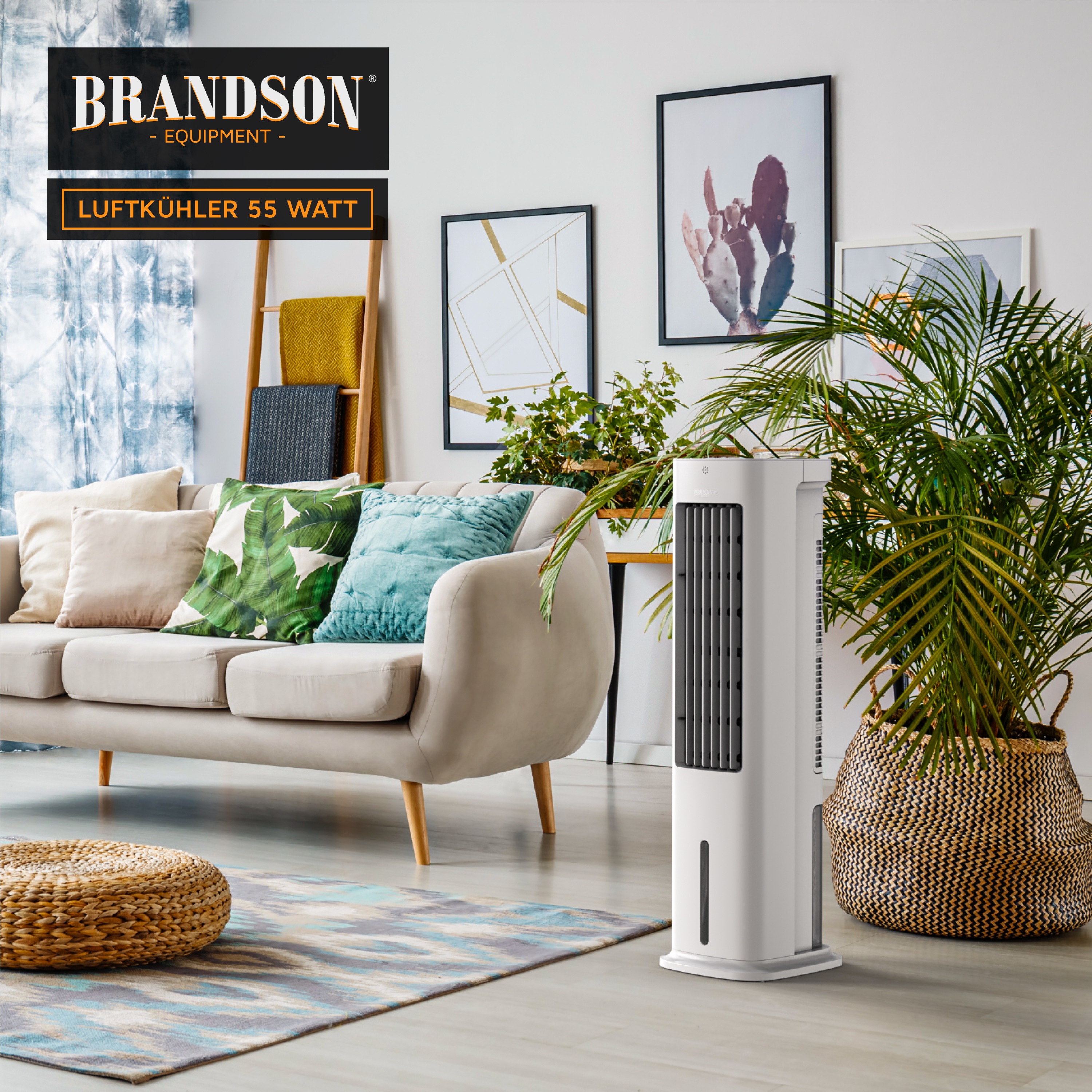Brandson Luftkühler in Weiß mit vertikalen Lüftungsschlitzen, auf einem hellen Boden neben einem Sofa und Pflanzen platziert.